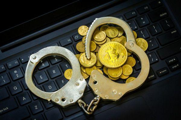 Bitcoin emas (cryptocurrency) dengan borgol di keyboard komputer. Shutterstock/Chat Karen Studio