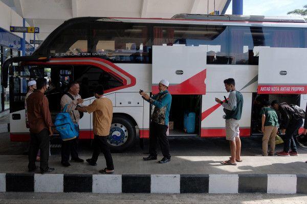 Penumpang bersiap-siap memasuki bus angkutan kota antar provinsi (AKAP) saat mudik ke kampung halaman di Terminal Mengwi, Badung, Bali, Senin (11/4).