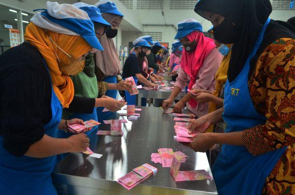 Pekerja menghitung uang Tunjangan Hari Raya (THR) yang diterimanya di pabrik rokok PT Djarum, Kudus, Jawa Tengah, Selasa (19/4).