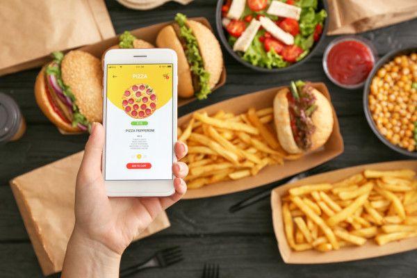 Ilustrasi perempuan memesan makanan secara online dengan ponsel. Shutterstock/Pixel-Shot.