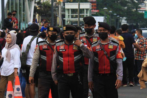Petugas kepolisian melakukan pengamanan di kawasan Dukuh Atas, Jakarta, Minggu (24/7). (