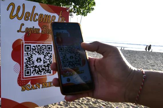 Wisatawan memindai QR Code saat akan memasuki kawasan wisata Pantai Legian, Badung, Bali, Sabtu (18/9/2021).