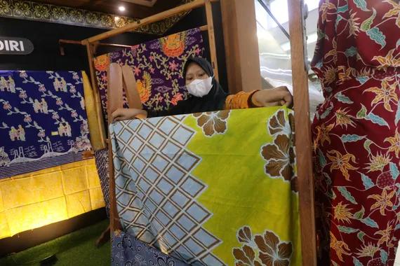 Perajin menata kain batik yang dipamerkan di Kediri Town Squer, Kota Kediri, Jawa Timur, Sabtu (2/10/2021).