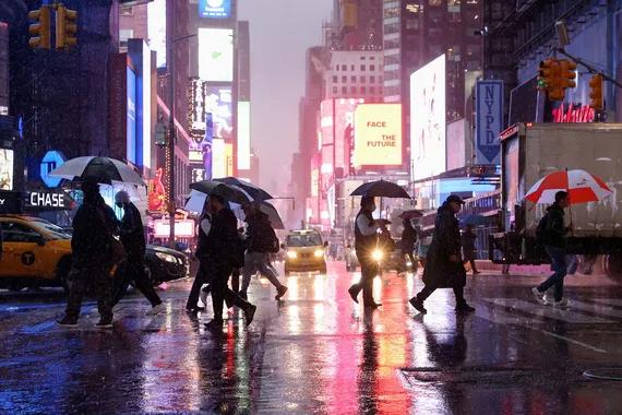 Warga memakai payung sambil menyebrangi jalan di New York, Amerika Serikat, Selasa (26/10/2021). ANTARA FOTO/REUTERS/Caitlin Ochs/aww/cfo