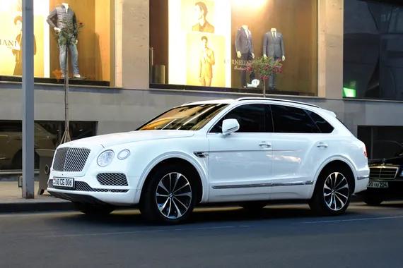 Salah satu SUV paling mewah di dunia! Bentley Bentayga putih mutiara di bawah lampu jalan. Shutterstock/Caddy Man