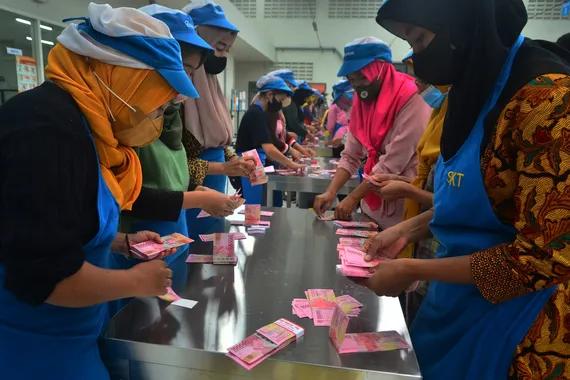 Pekerja menghitung uang Tunjangan Hari Raya (THR) yang diterimanya di pabrik rokok PT Djarum, Kudus, Jawa Tengah, Selasa (19/4).